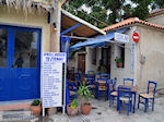 Blauwe tafeltjes and stoelen near een echte souvlakitent in Skala Eressos - Photo JustGreece.com